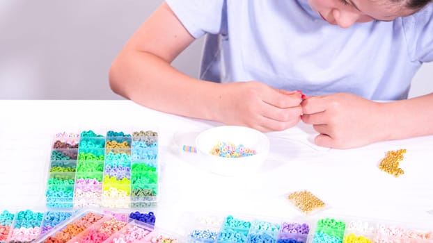 Delicate fingers of a young girl navigate through a treasure trove of bright, multicolored beads, each compartment revealing a new hue to choose from.