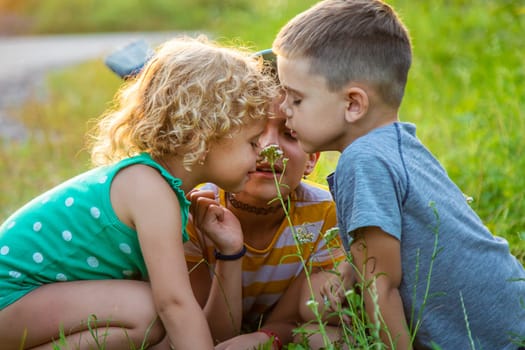 Children look through a magnifying glass together at the plants in the garden. Selective focus. Kid.