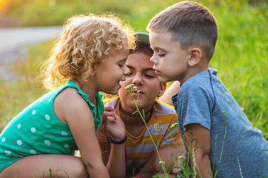 Children look through a magnifying glass together at the plants in the garden. Selective focus. Kid.