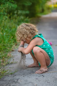 Children play with sand on the street. Selective focus. Kids.