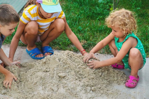 Children play with sand on the street. Selective focus. Kids.