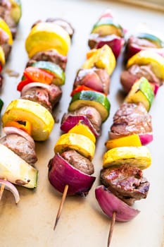 Flavorful beef and colorful veggie skewers, marinated and grilled to perfection, sizzling on a baking sheet.