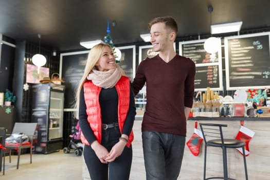 Happy smiling couple embracing in coffee shop in autumn winter season