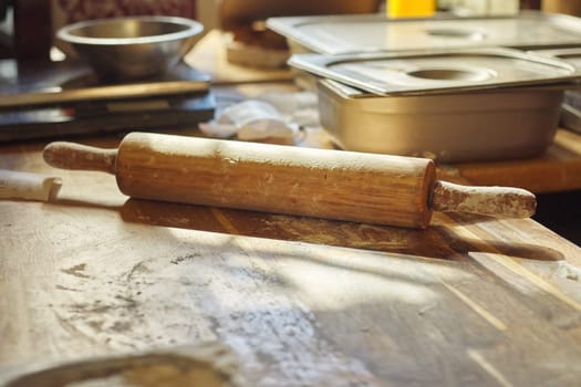 Wooden table in the kitchen with flour, rolling pin dough, nobody, the process of making flour baking, copy space