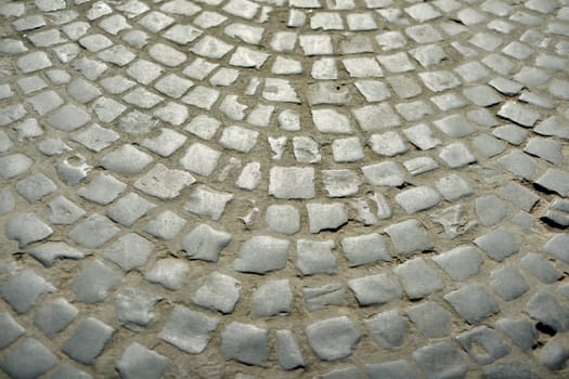 Old round paving stones of gray stones, abstract background texture