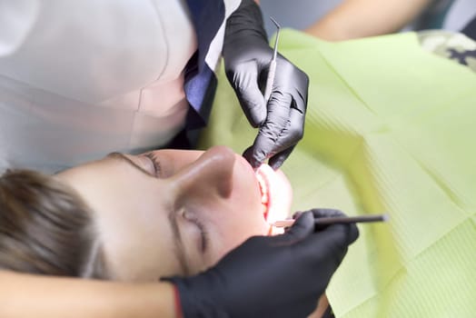 Close up dental treatment procedure in dental office. Dentistry, healthy teeth, medicine and healthcare concept