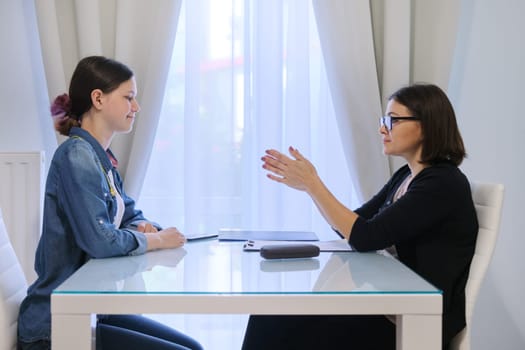 Teenager psychologist, female social worker talking to teenage girl.