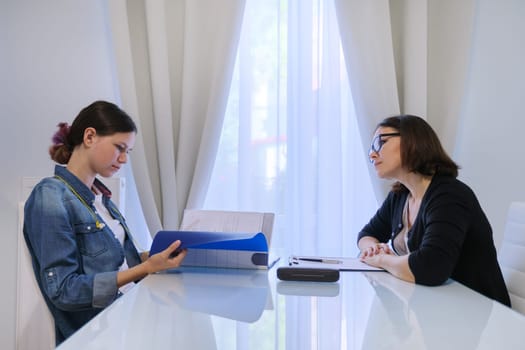 Teenager psychologist, female social worker talking to teenage girl.