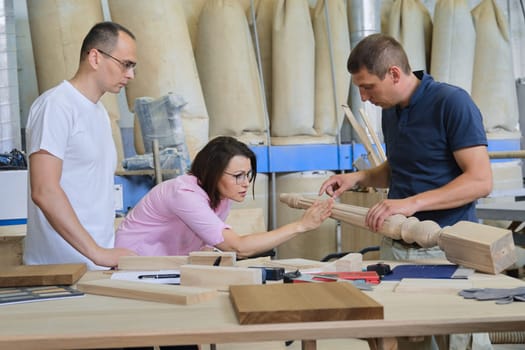Industrial woodworking workshop, team of people discussing carpentry process, new products