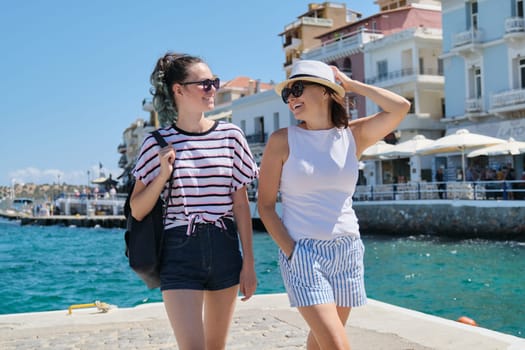 Traveling tourism to Europe Mediterranean, happy mother and daughter teenager walking, summer sea vacation. Greece Mirabello Bay, Agios Nikolaos