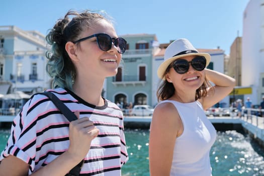 Walking happy mother parent and teenage daughter summer holidays together in resort sea town