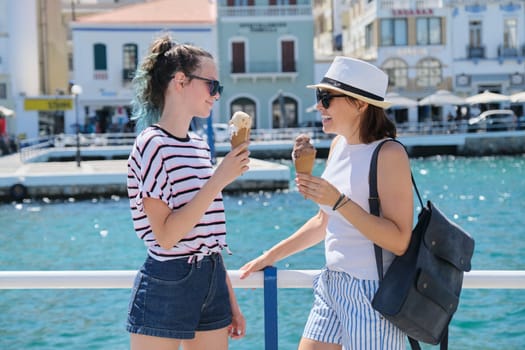 Europe tourist travel cruise vacation. Happy mother and daughter teenager with ice cream talking walking. Greece Mirabello Bay, Agios Nikolaos