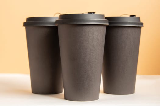 Set of three takeaway black coffee cup on neutral background. Mock -up, nobody, front view