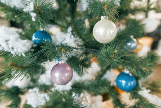 Background christmas tree decorated with toys balls.