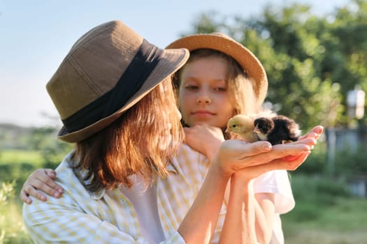 Country rustic style, happy mom and daughter together with newborn baby chickens. Nature, farm, healthy lifestyle and food, golden hour.