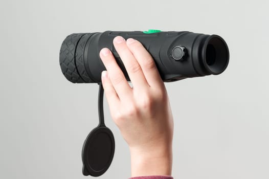 The child is holding a monocular on a white background, a long-range thermal imager.