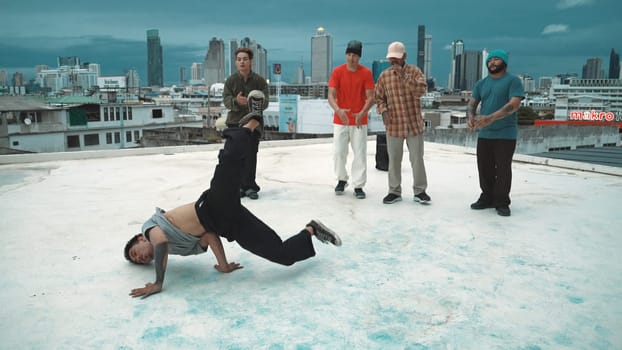 Hispanic hipster dancing surrounded by multicultural friend at city view with blue sky. Group of street dancer performing at rooftop. Active, fun, happy atmosphere. Outdoor sport 2024. Endeavor.