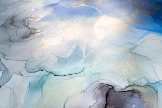 Abstract art with blue and gold background, beautiful smudges and stains made with alcohol ink. Abstract painting, background for wallpapers, posters, cards, invitations, websites.