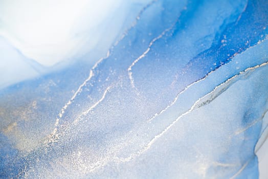 Abstract art with blue and gold background, beautiful smudges and stains made with alcohol ink. Abstract painting, background for wallpapers, posters, cards, invitations, websites.