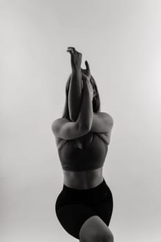 Beautiful woman doing Lotus of Padmasana or Kamalasana pose on a yoga class. Studio shot.