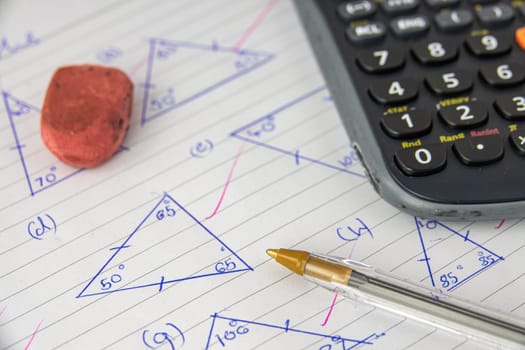 A Child's Math (Geometry) Homework Or Exam, With Calculator, Pen And Eraser