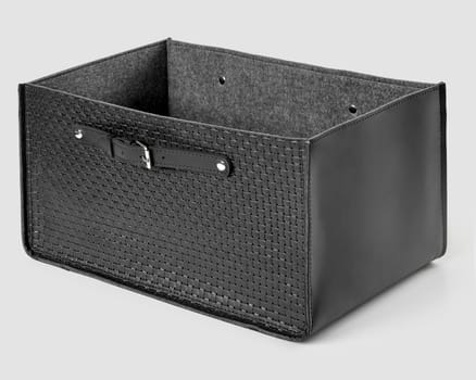 Functional comfortable storage bin with black braided leather exterior and soft grey felt lining on white background. Stylish interior accessory for organizing space