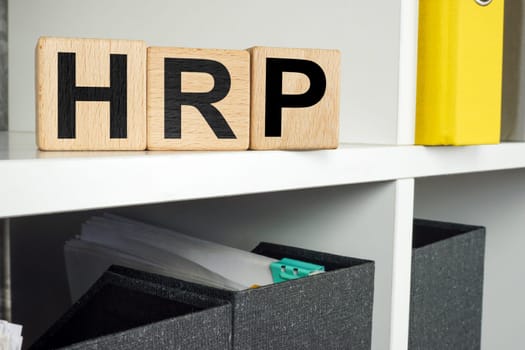 HRP human resource planning concept. Wooden cubes lie on office shelf.