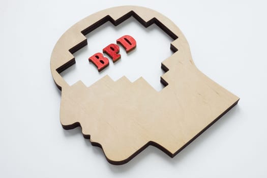 Wooden head with letters BPD Borderline personality disorder.