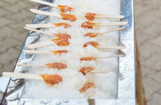 Row of hot maple syrup on a stick on the snow
