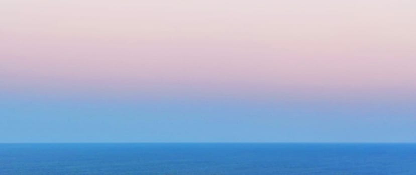 Pink morning sky over sea horizon, panoramic photo for pastel background, space for text.