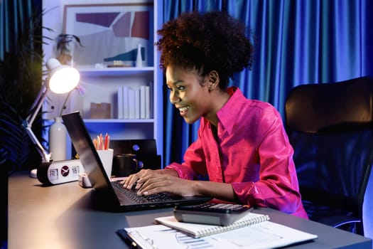 Working African woman with happy glowing, smiling face, getting new job project with good deal or marketing course scholarship information on laptop screen. Concept of cheerful expression. Tastemaker.