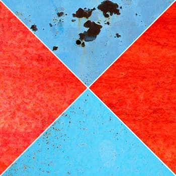 Red and blue metal and paint creating textured wall background, collage