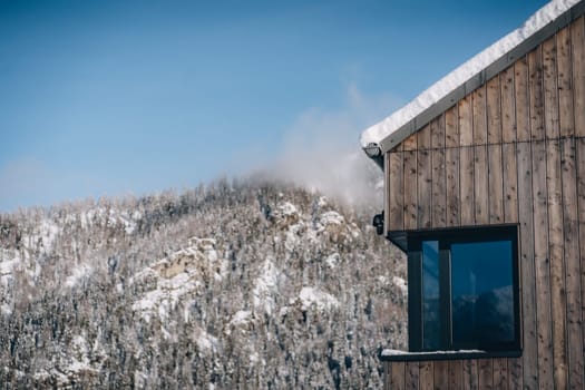 Modern wooden cabin with window and snowdrift on roof, house in Low Tatras, Slovakia