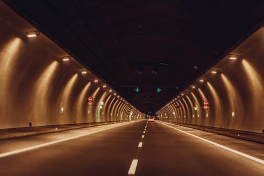 Underground road tunnel, night illuminated concrete long tube with car for transportation