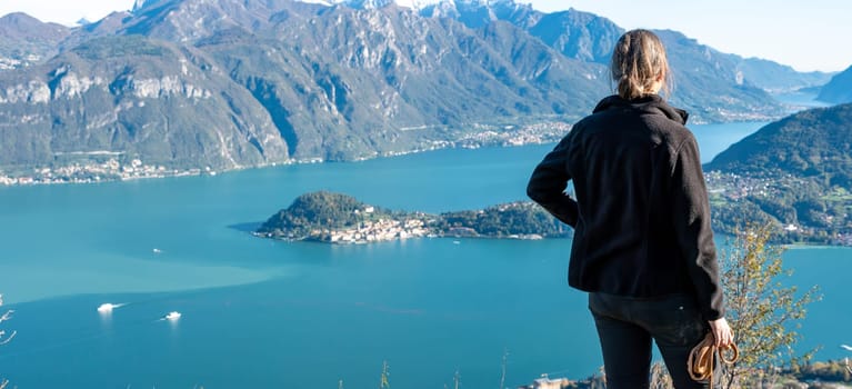 A hiker enjoying the magnificent view of Bellagio at lake Como seen from Monte Crocione, Italy