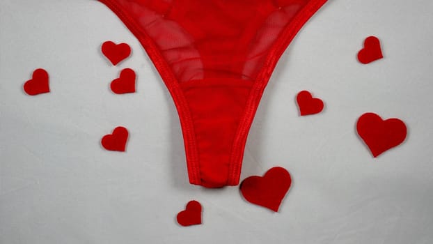 Valentine's Day Sexy Underwear Red Mesh Micro Panties Thong Hold Up String. Close-up in focus on white isolated background. with hearts