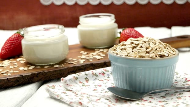 Strawberries desert with cream and cereals served on glass cups over table top.