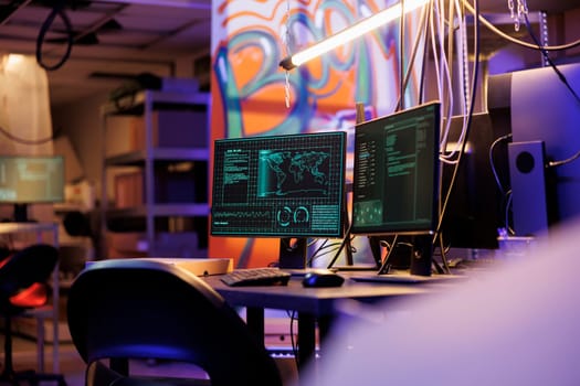 Hacker malicious software breaking into database on computer screens. Malware breaching data and cracking server password on monitors in abandoned warehouse with graffiti