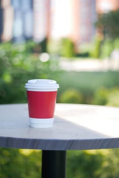 Blank take away kraft coffee cup on table