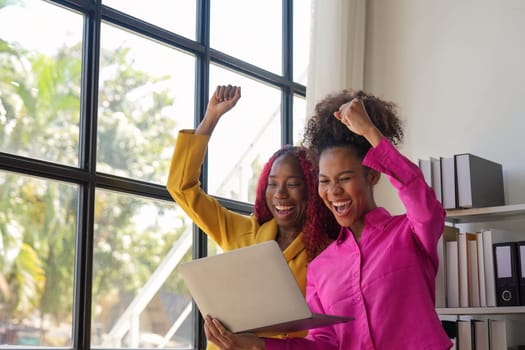 Two african woman celebrate when business goal success. achievement and business goal success concept.