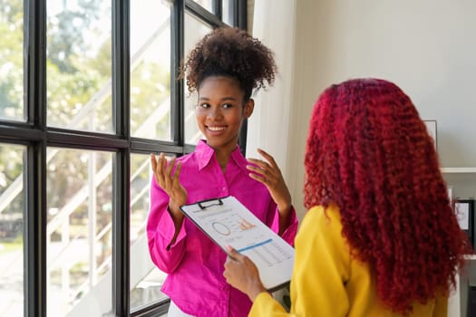 Two businesswoman African American working together talking about a business project. team of females executives meeting work in office.