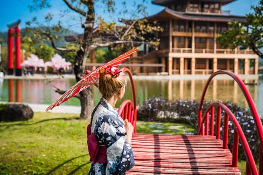 Asian girl in kimono and umbrella in Japanese theme park Hinoki Land in Chai Prakan District, Chiang Mai