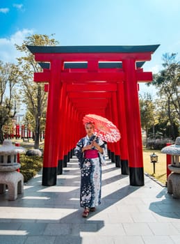 Asian girl in kimono and umbrella in Japanese theme park Hinoki Land in Chai Prakan District, Chiang Mai