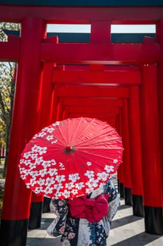 Asian girl in kimono and umbrella in Japanese theme park Hinoki Land in Chai Prakan District, Chiang Mai