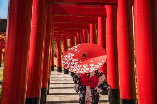 Asian girl in kimono and umbrella in Japanese theme park Hinoki Land in Chai Prakan District, Chiang Mai