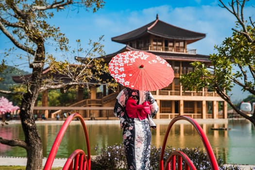 Asian girl in kimono and umbrella in Japanese theme park Hinoki Land in Chai Prakan District, Chiang Mai