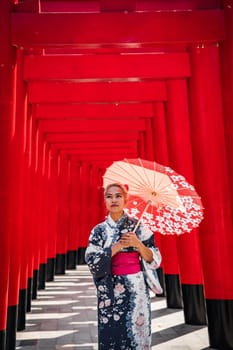 Asian girl in kimono and umbrella in Japanese theme park Hinoki Land in Chai Prakan District, Chiang Mai