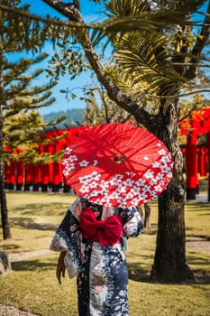 Asian girl in kimono and umbrella in Japanese theme park Hinoki Land in Chai Prakan District, Chiang Mai