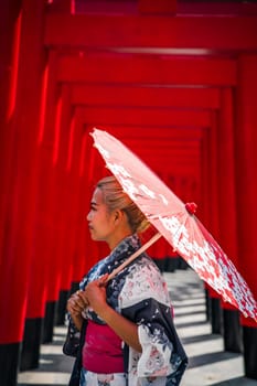 Asian girl in kimono and umbrella in Japanese theme park Hinoki Land in Chai Prakan District, Chiang Mai