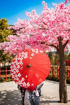 Asian girl in kimono and umbrella in Japanese theme park Hinoki Land in Chai Prakan District, Chiang Mai